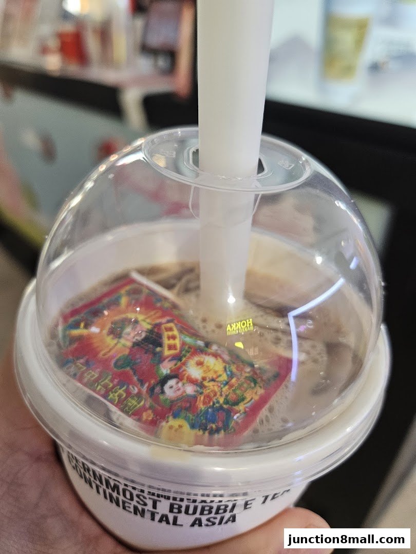 A close-up of a LiHO TEA bubble tea with a festive Chinese New Year themed sticker on top.