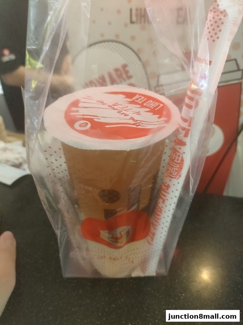 A plastic bag containing a LiHO TEA drink with a straw.