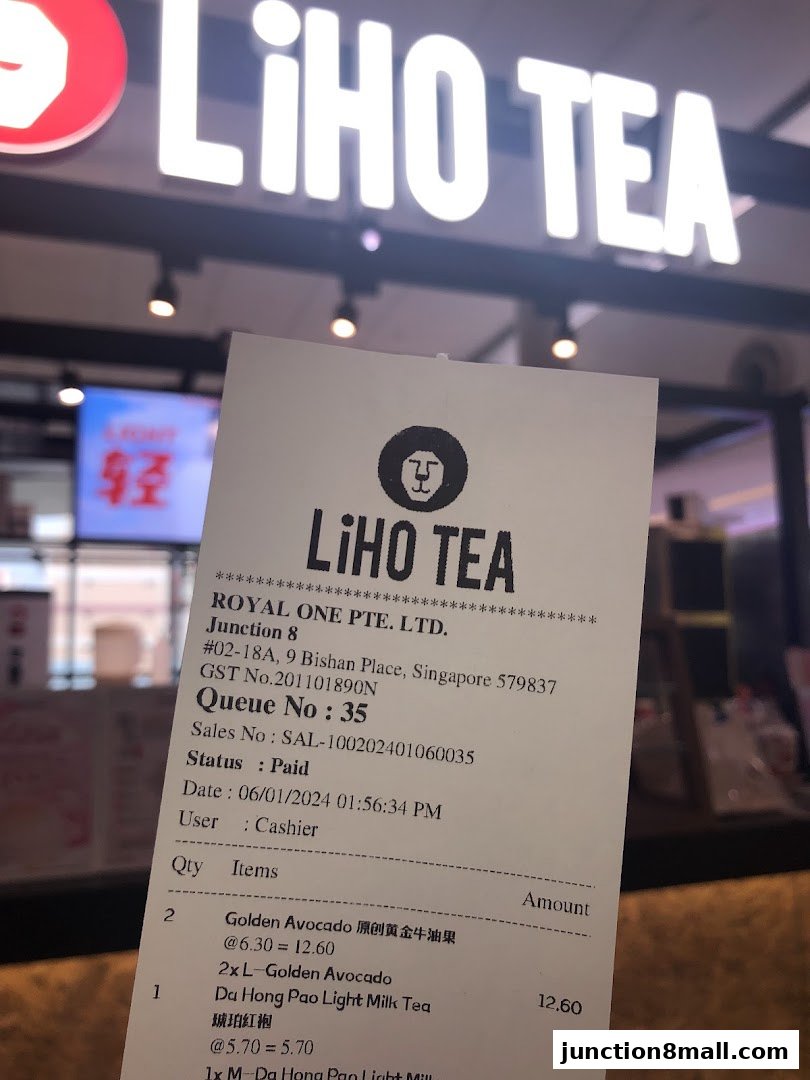 A receipt from LiHO TEA with drinks purchased in front of the shop's illuminated sign.