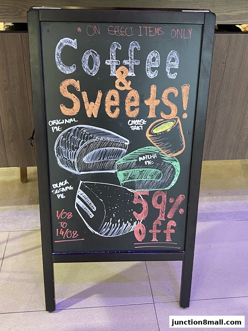 A chalkboard sign advertising coffee and sweets with a 59% off promotion.