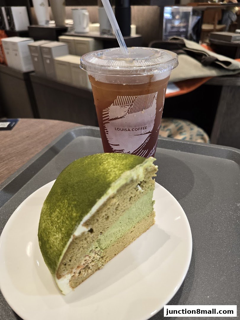 A slice of matcha cake and a cold drink from Louisa Coffee on a tray.