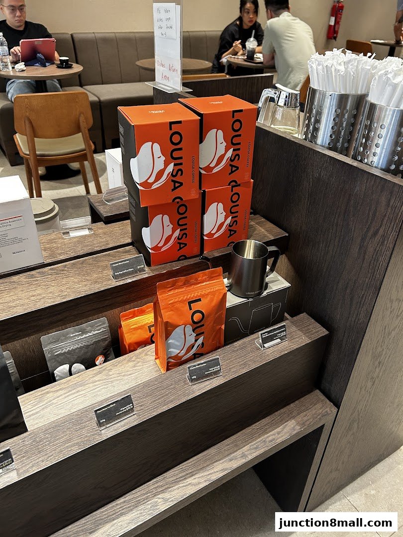 Louisa Coffee shop interior with branded coffee boxes and bags on display.