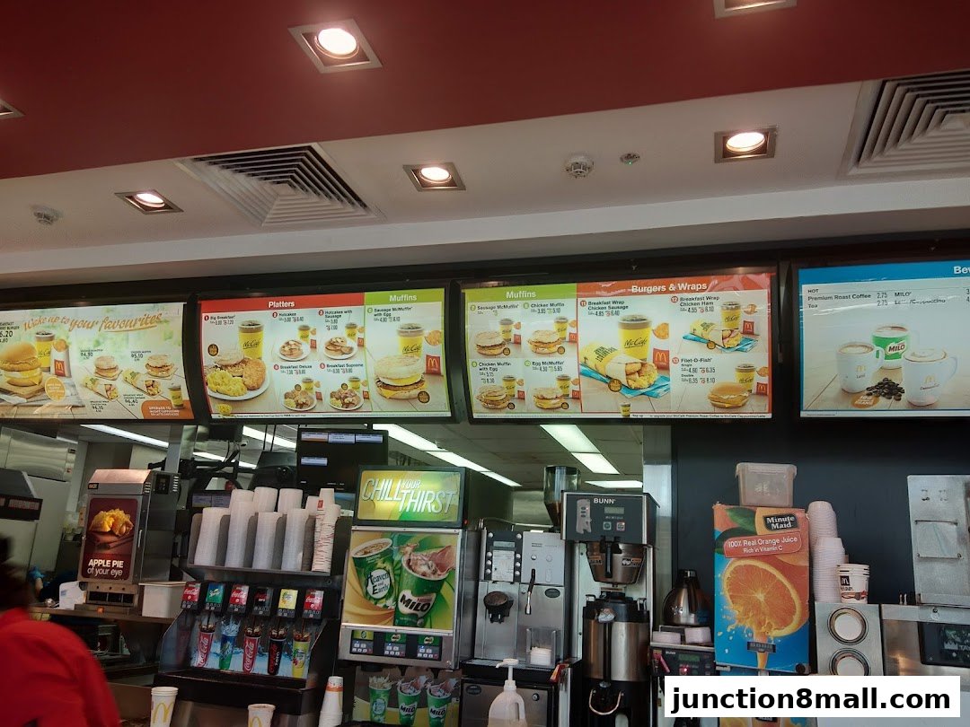 McDonald's menu boards displaying breakfast items, burgers, wraps, and beverages.