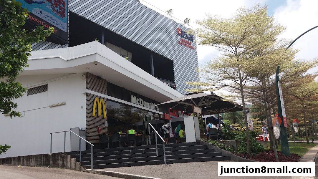 Exterior view of a McDonald's restaurant with outdoor seating and a modern building facade.