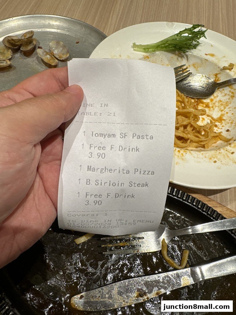 A receipt from Milan Shokudo Junction 8 showing a meal with pasta, pizza, steak, and drinks.