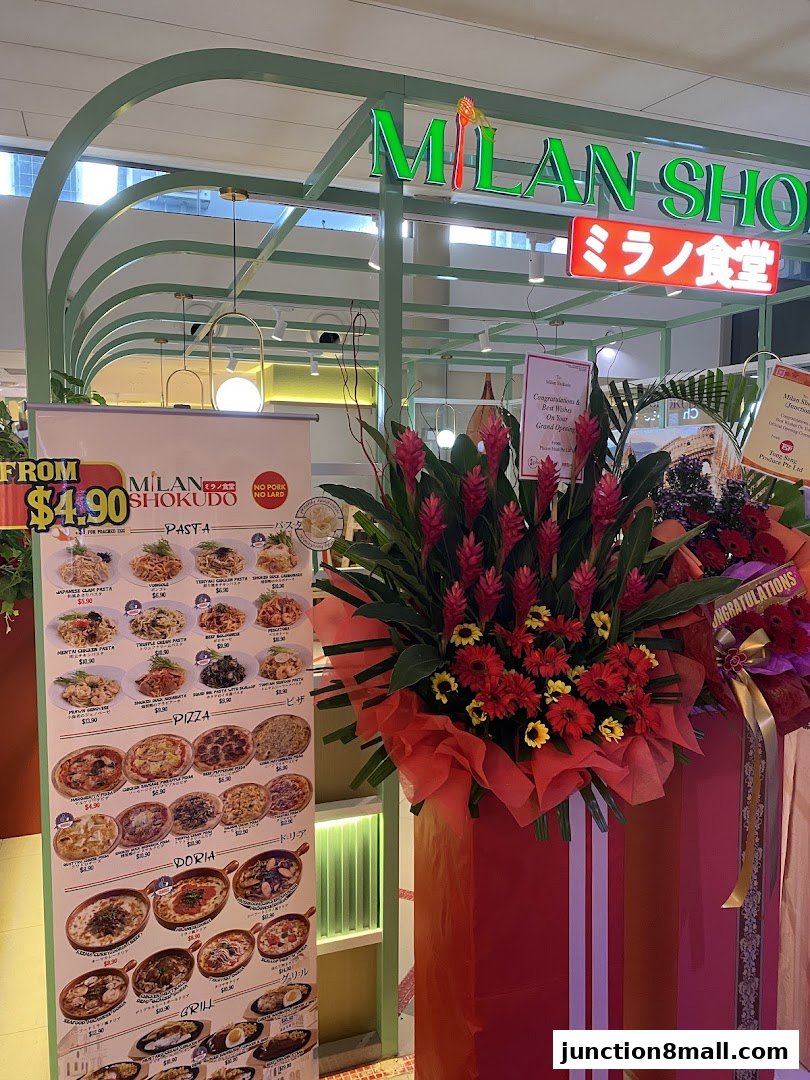 Milan Shokudo Junction 8 shop front with a menu display and congratulatory flower arrangements.