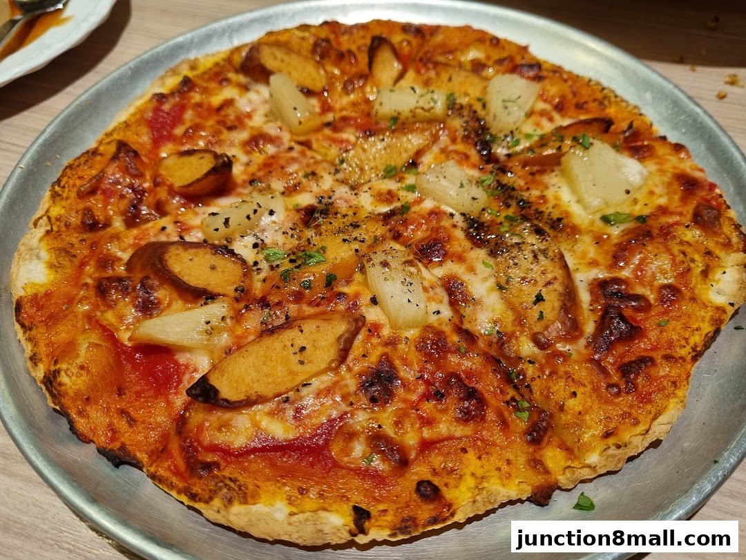 A close-up shot of a delicious-looking pizza with cheese, sausage, and pineapple.