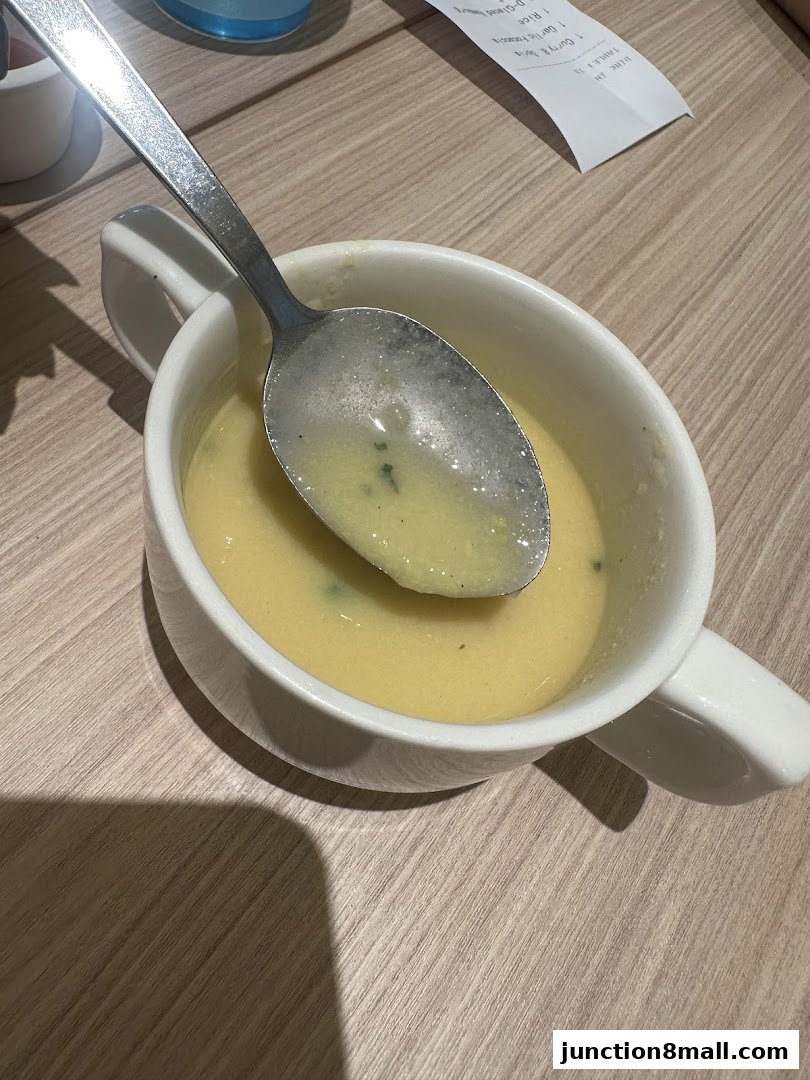 A close-up shot of a bowl of creamy soup with a spoon resting inside.