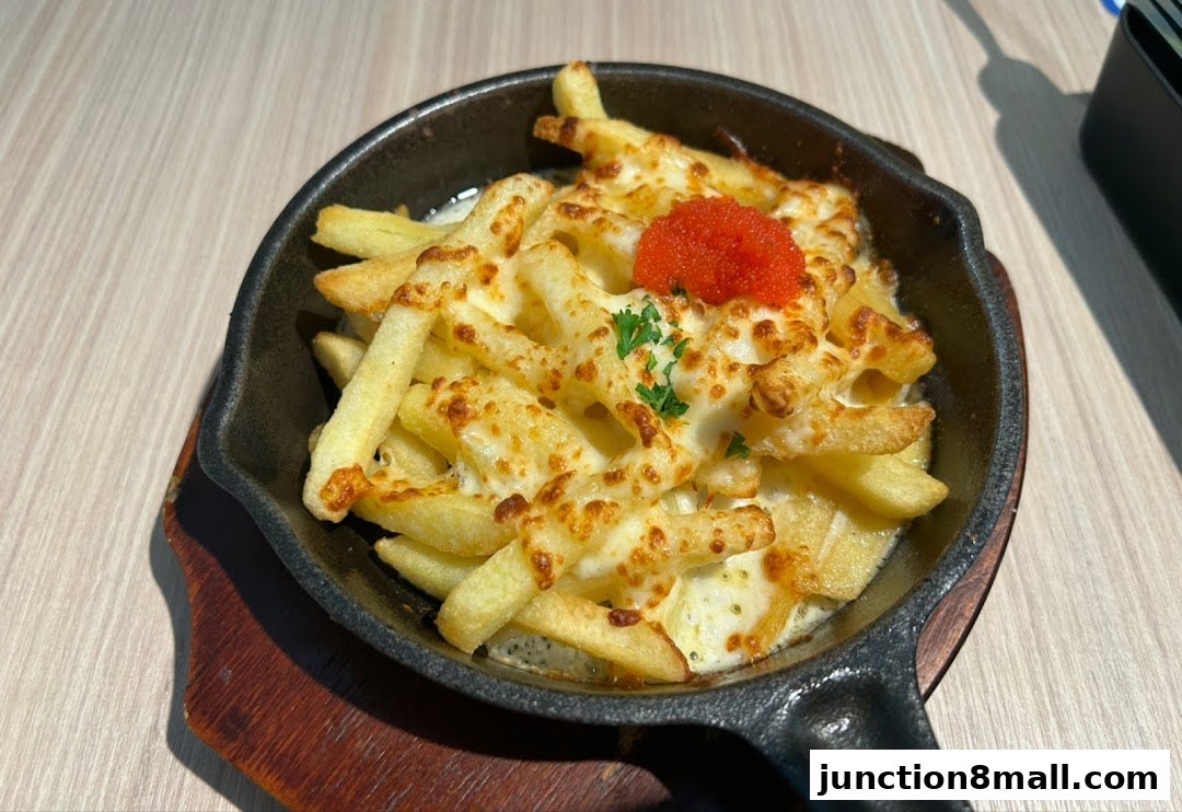 A close-up shot of cheesy fries topped with roe and parsley in a cast-iron skillet.