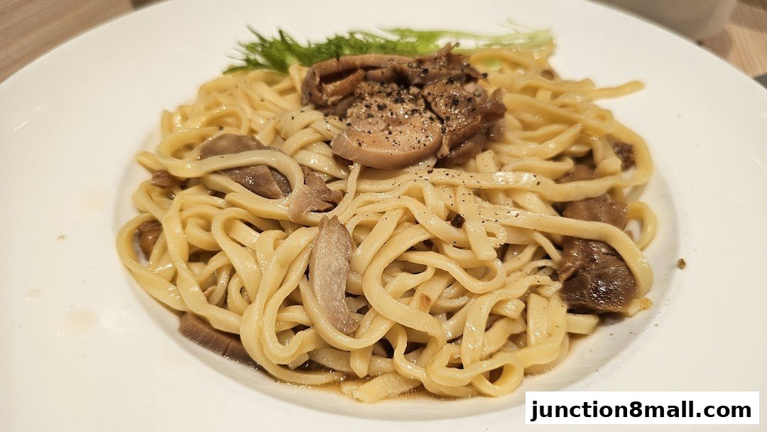 A close-up shot of a plate of pasta with mushrooms and a garnish of greens.