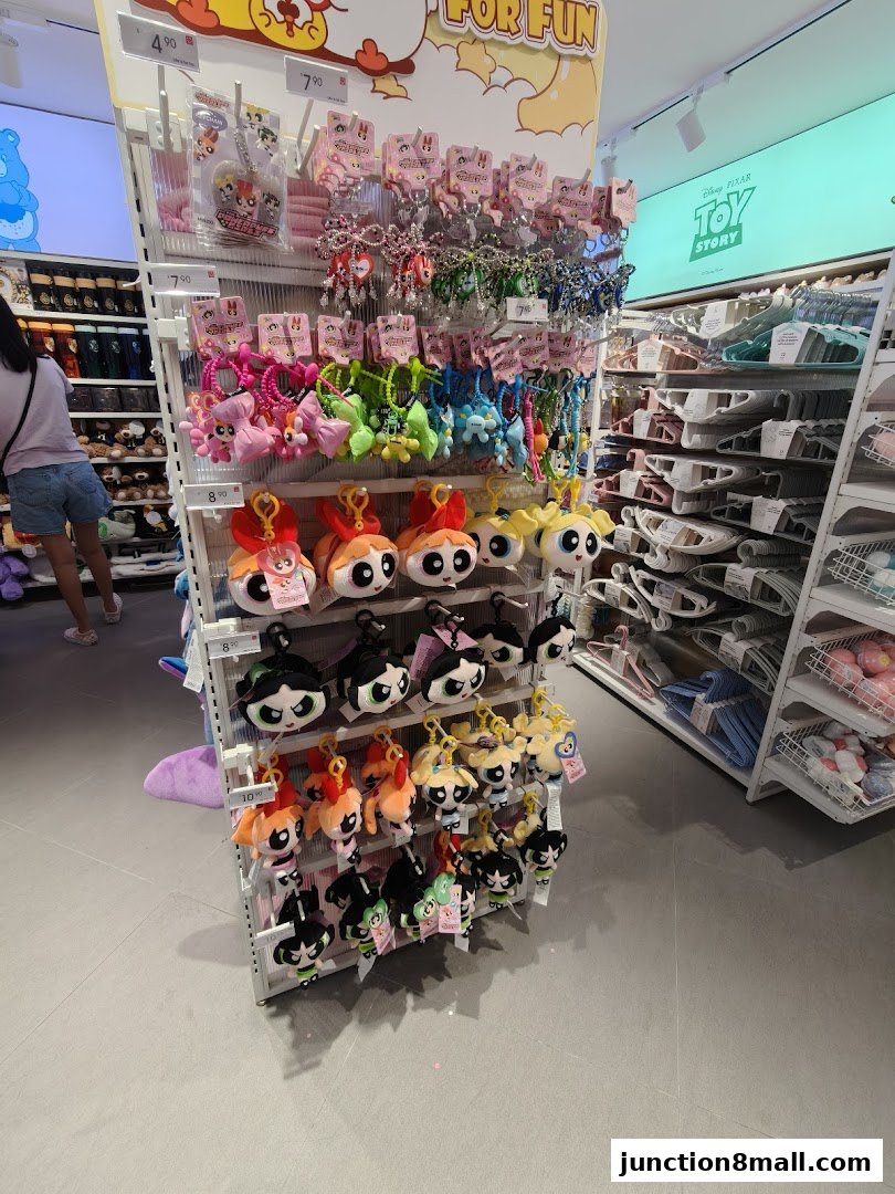 A display of Powerpuff Girls plush keychains and other accessories in a retail store.
