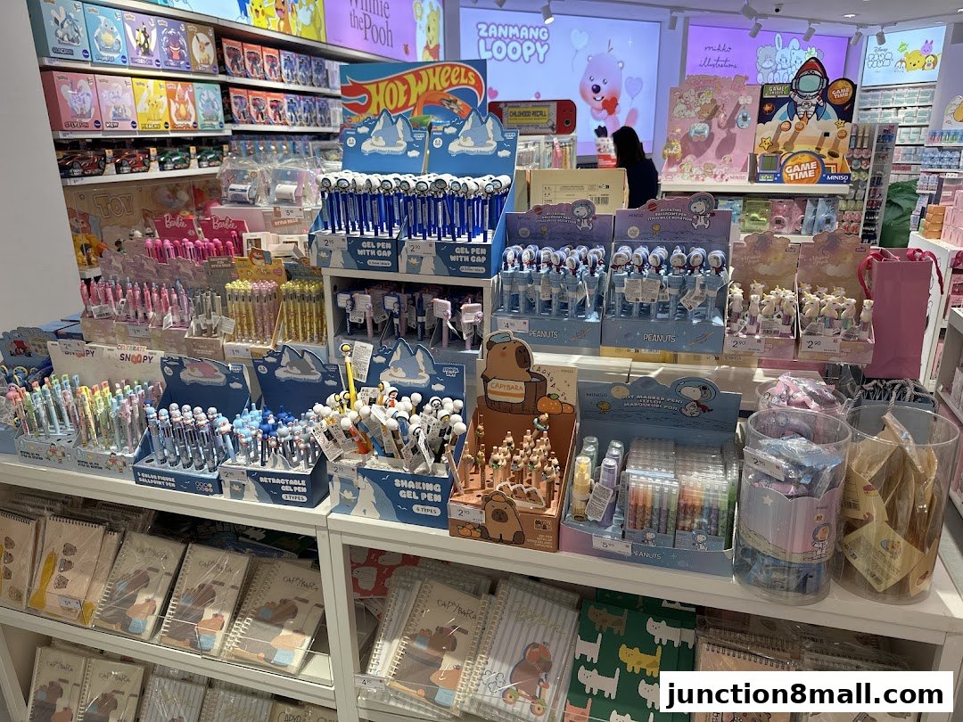 A brightly lit shop interior displaying a wide variety of colorful pens, stationery, and character merchandise.
