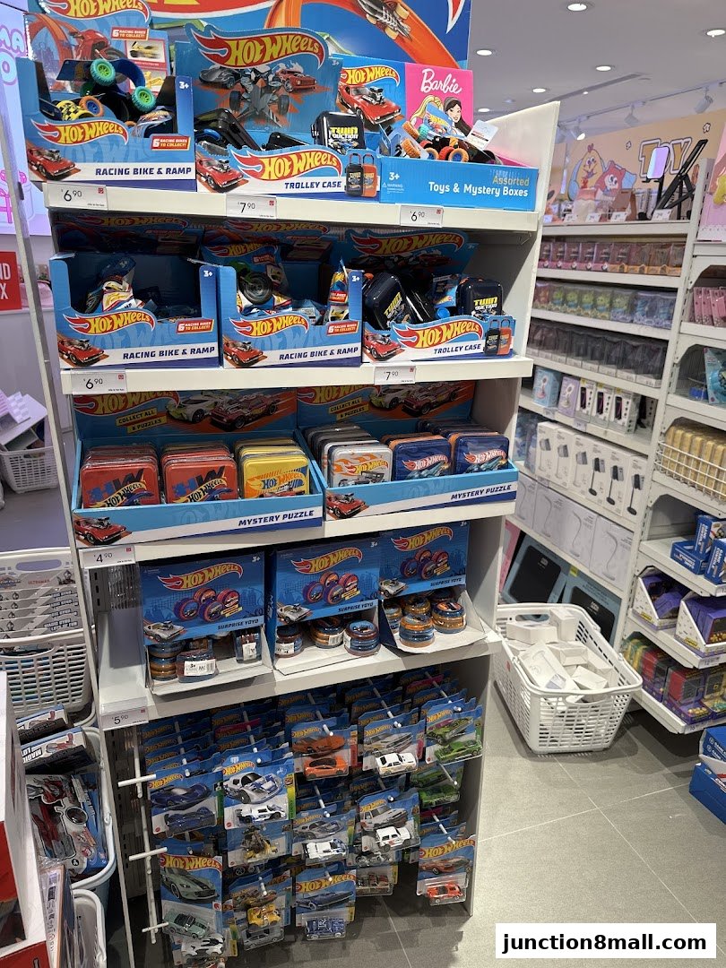 A display of Hot Wheels toys including racing bikes, ramps, trolley cases, and mystery puzzles.