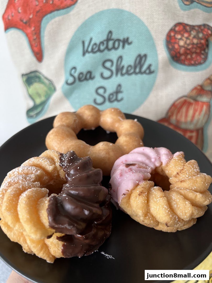 A black plate holds three assorted Mister Donut Pon de Ring donuts.