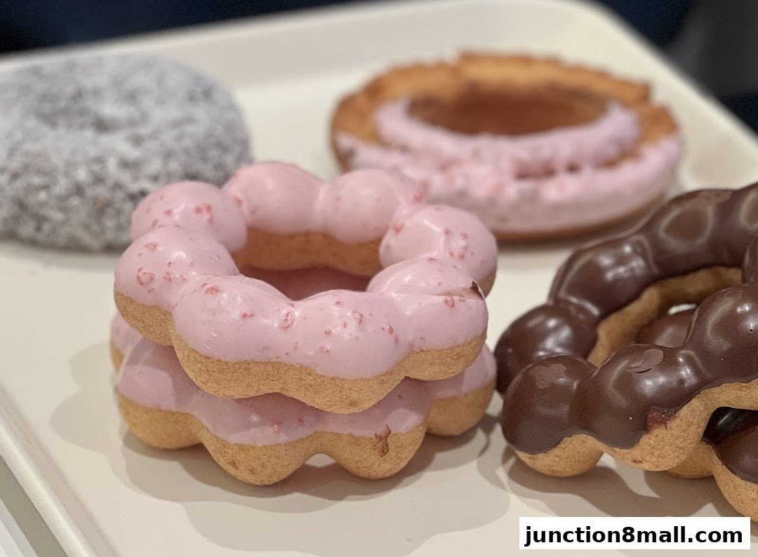 A close-up shot of several colorful donuts on a white tray.