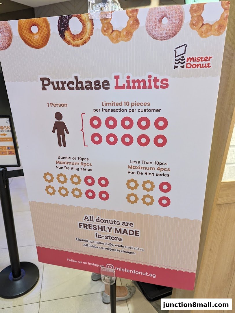 A sign detailing purchase limits for donuts at Mister Donut, highlighting freshly made in-store.