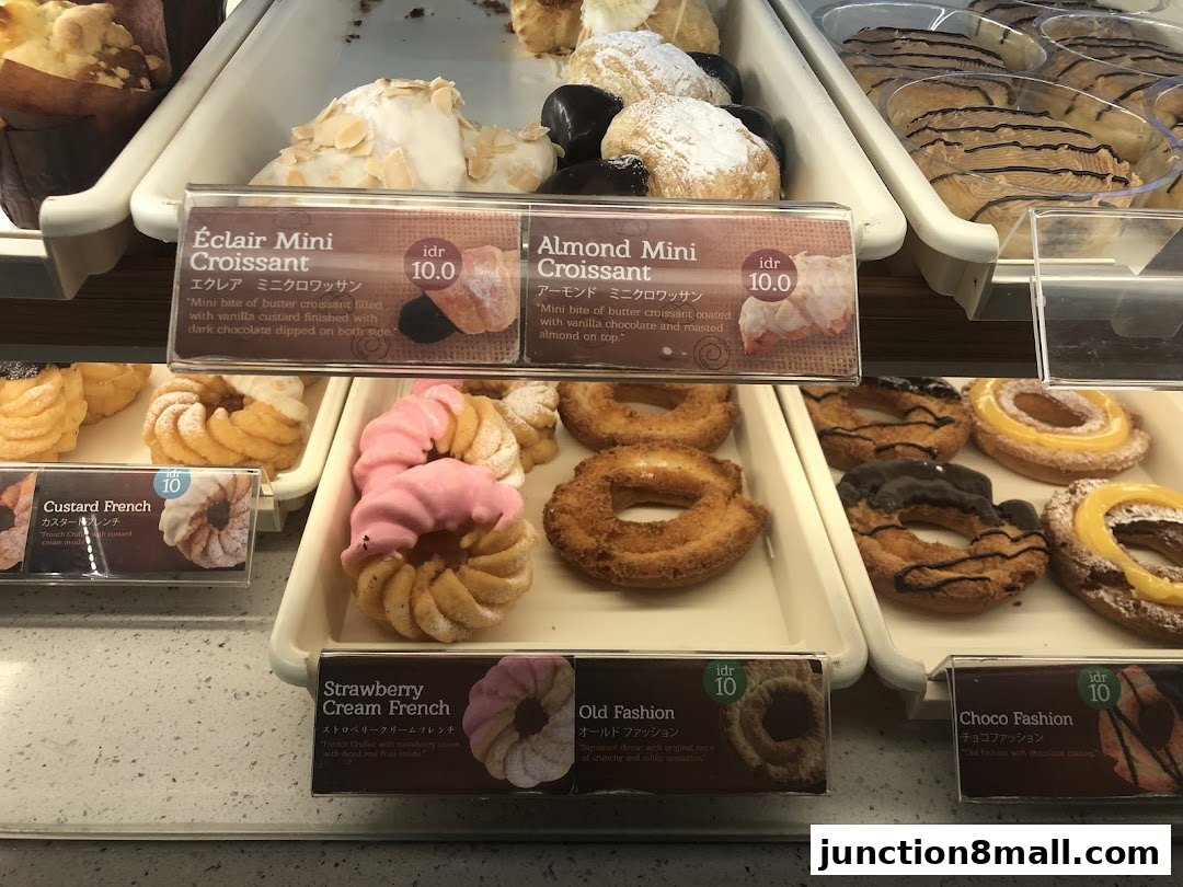 A display case filled with various donuts and pastries at Mister Donut.