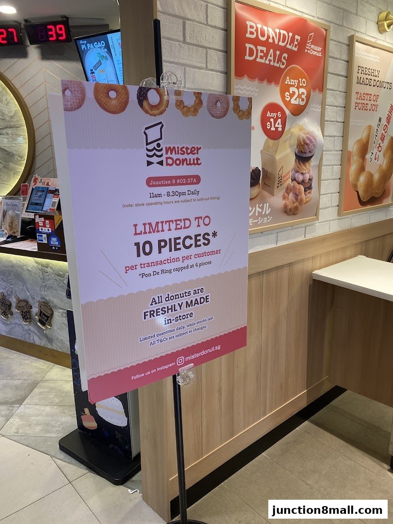 A sign at Mister Donut advertises a limit of 10 pieces per transaction and freshly made donuts.