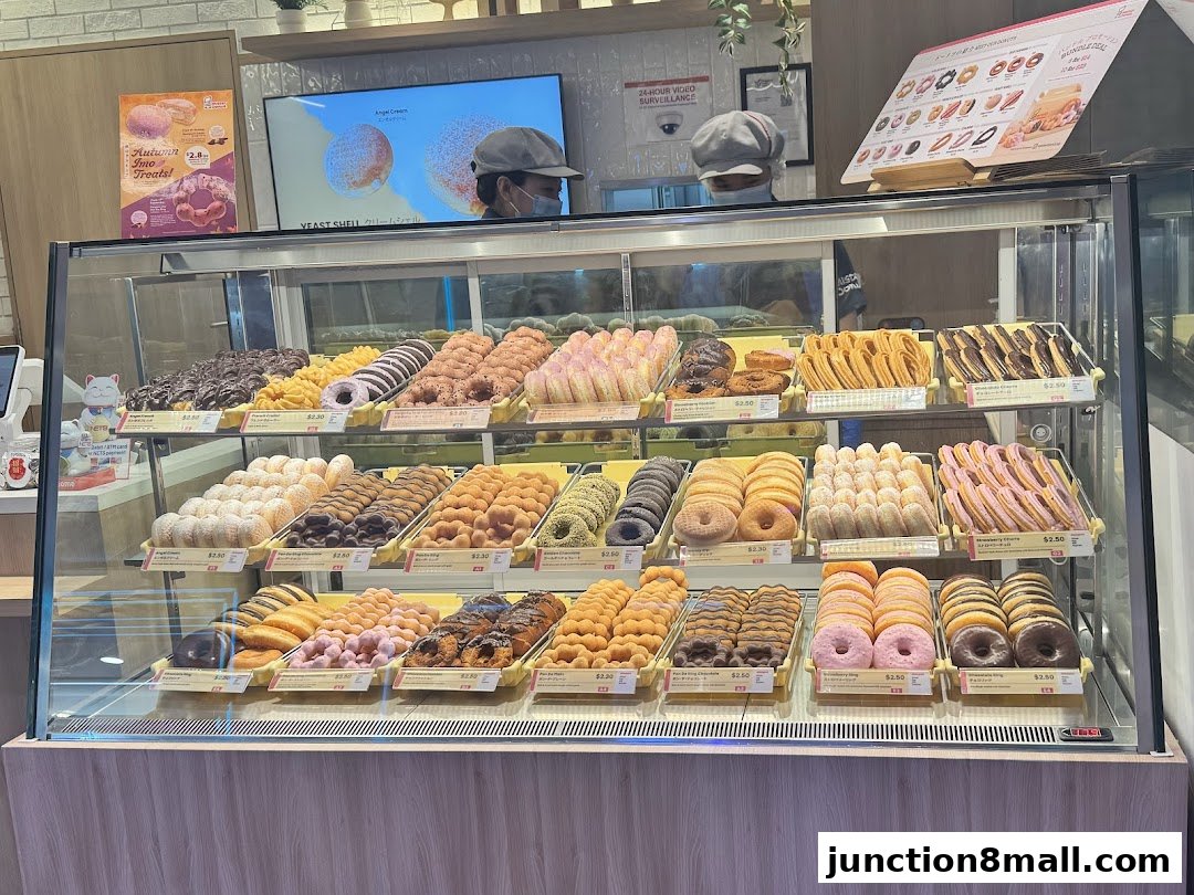 A display case filled with a variety of colorful donuts and pastries at Mister Donut.
