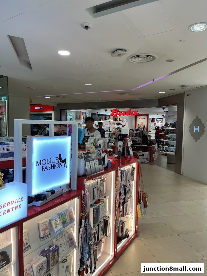 A brightly lit mobile accessories stall with various phone cases and lanyards on display.