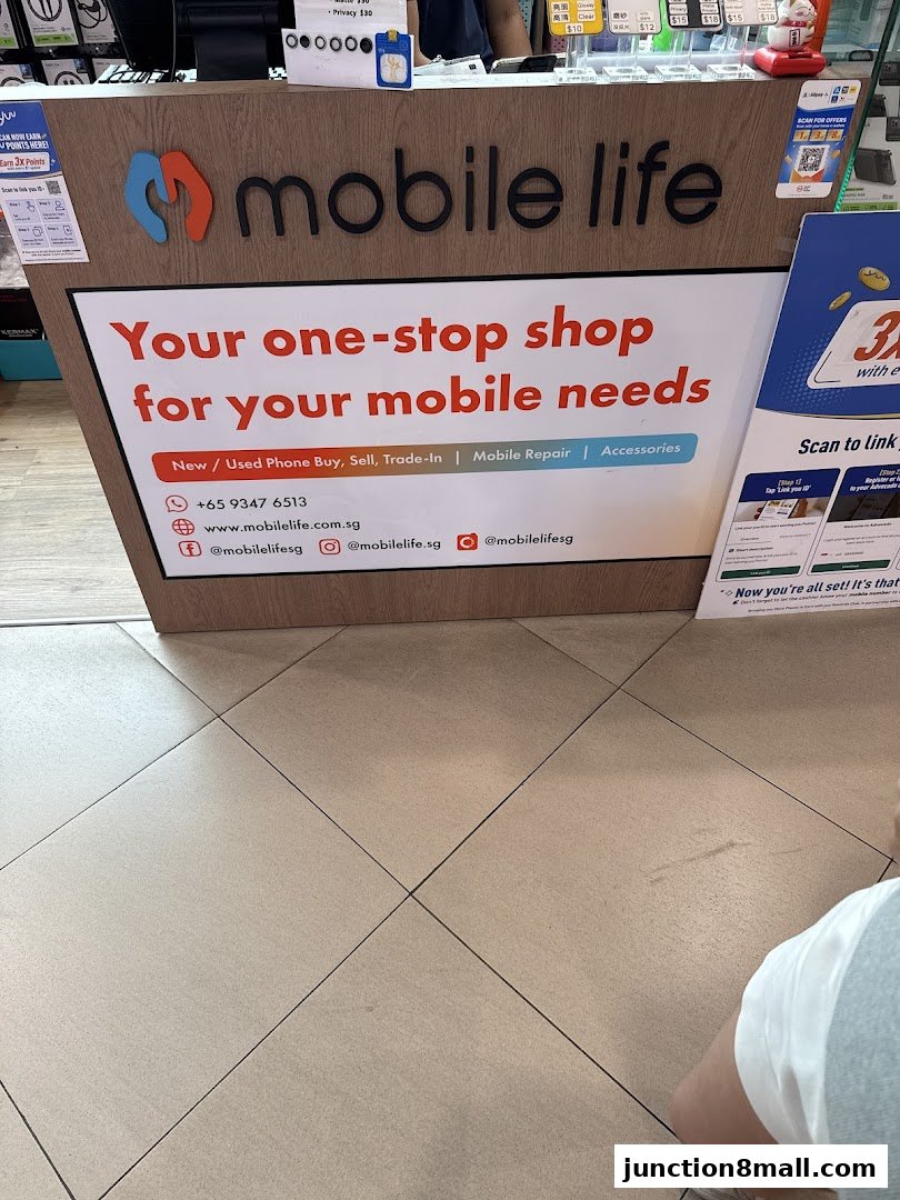 A shop counter with the 'Mobile Life' logo and a sign advertising mobile services and accessories.