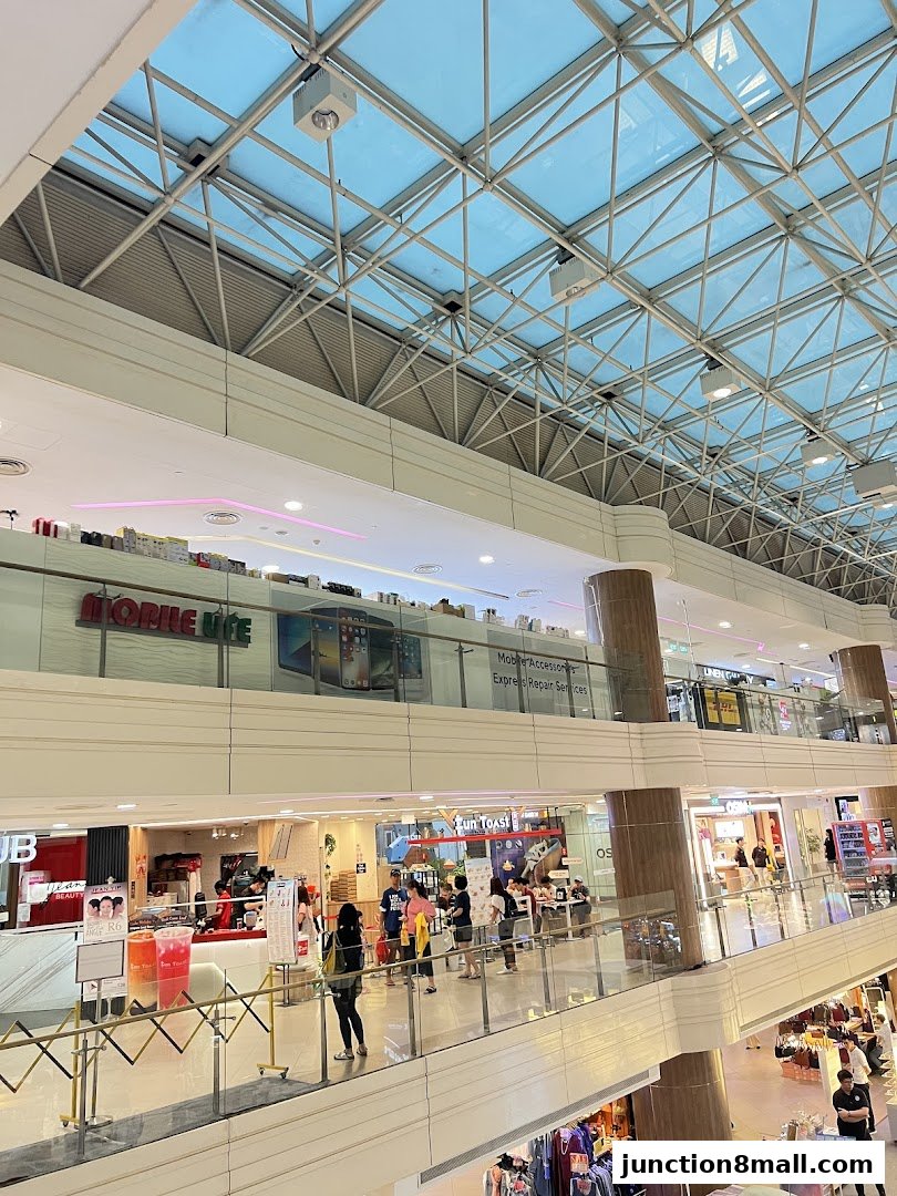 A view of a shopping mall interior with various shops and people browsing on different levels.