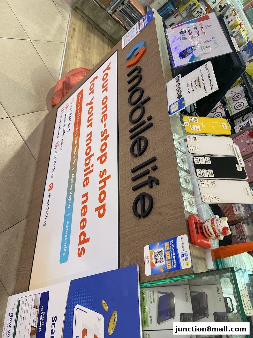 A shop counter displaying the 'Mobile Life' logo and various phone accessories.
