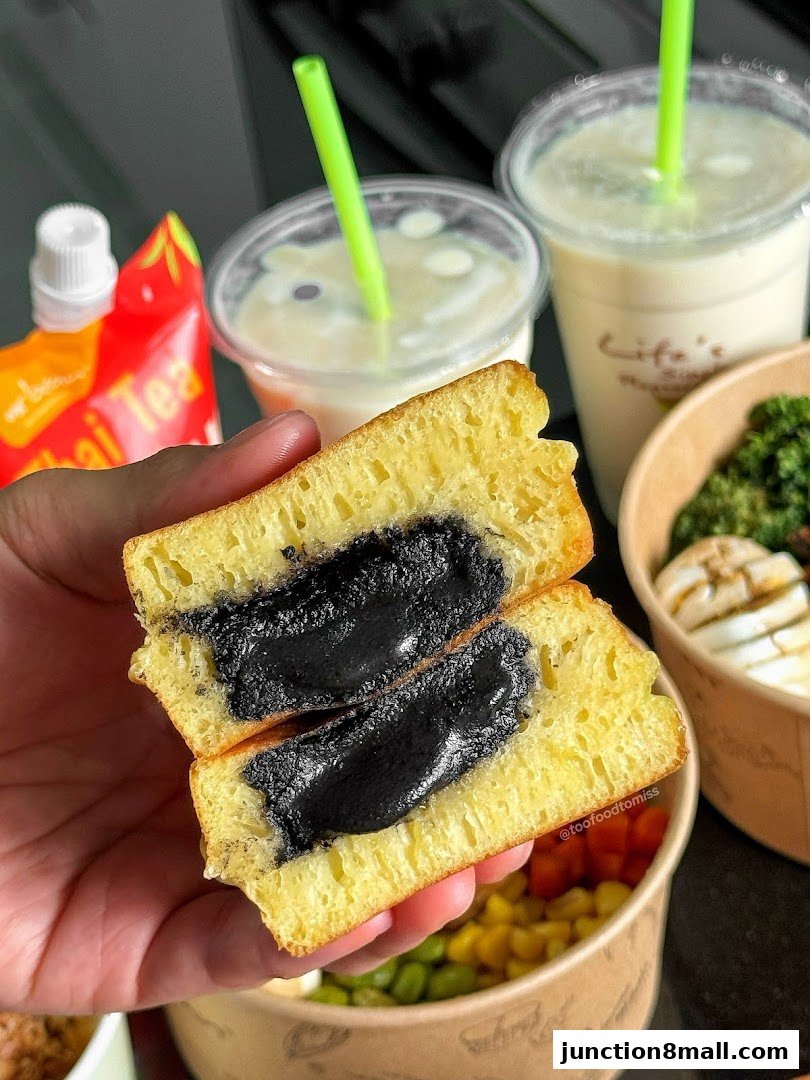 A close-up of a sweet pancake filled with black sesame paste, served with drinks and side dishes.