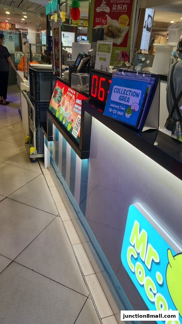 A counter area with a digital display showing '06' and a 'Collection Area' sign.