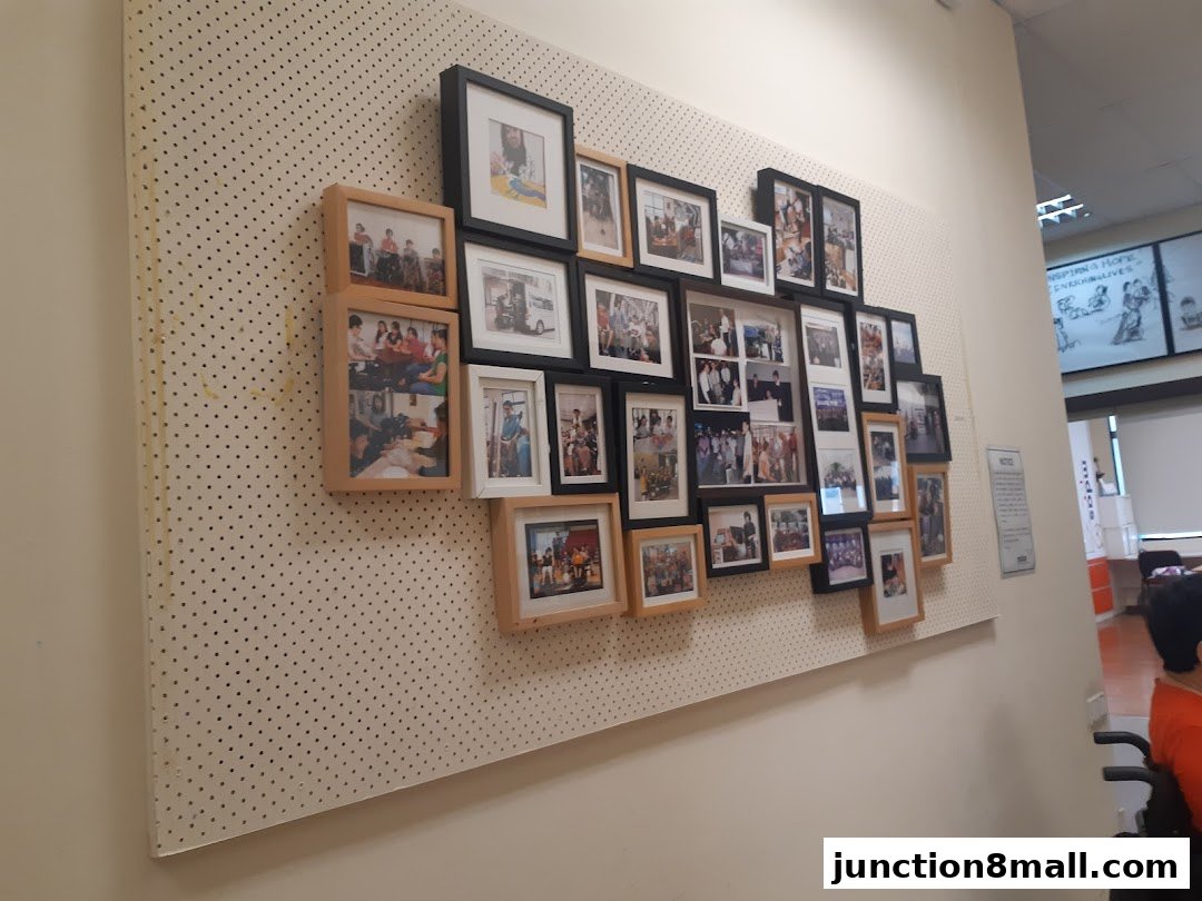 A wall display featuring numerous framed photographs showcasing events and people.