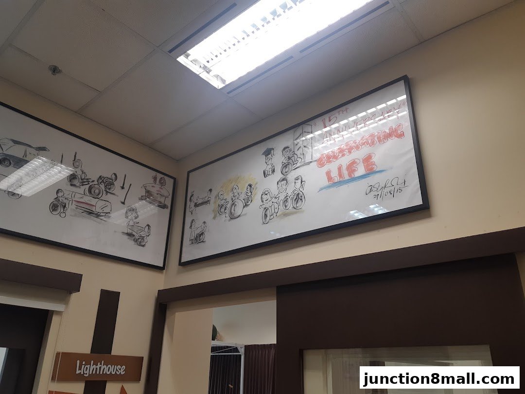 Framed artwork depicting people in wheelchairs and celebratory text on a wall.