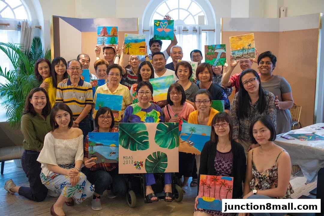 A diverse group of people proudly display their artwork, smiling at the camera.