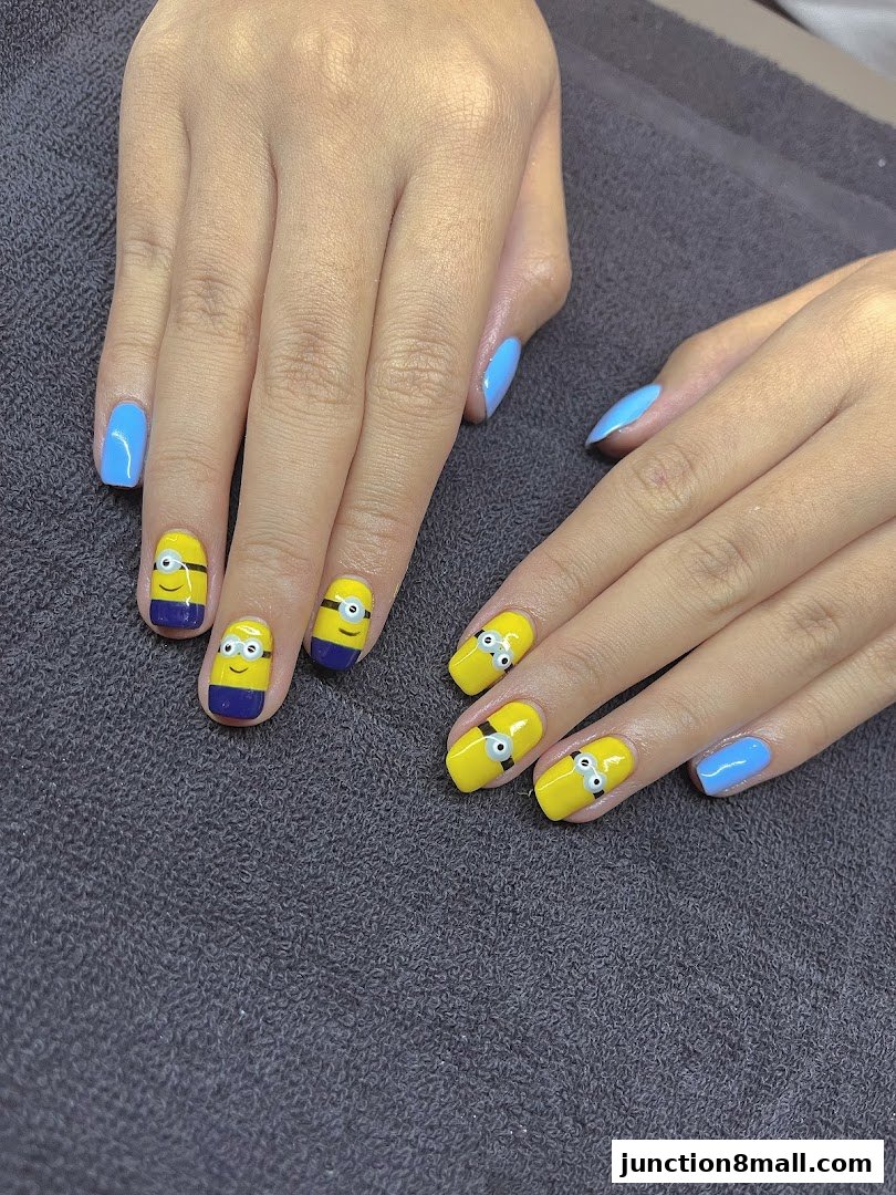 Close-up of hands with bright blue and Minion-themed nail art.