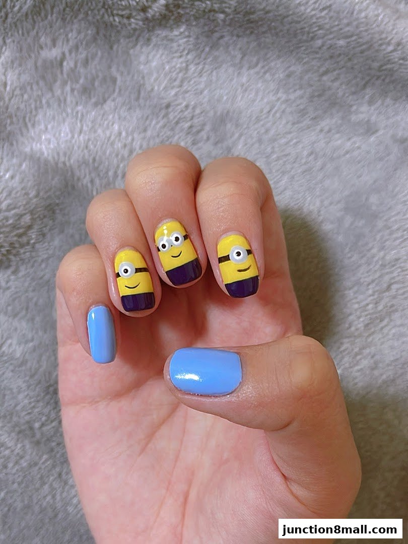 A hand with light blue nails and Minion-themed nail art.