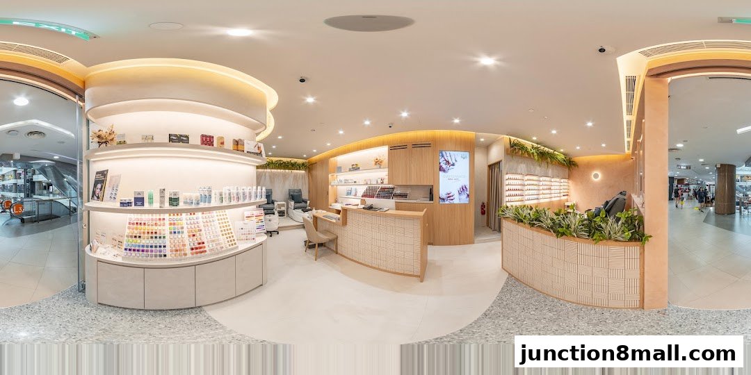Interior view of a modern nail salon with a reception desk, nail polish displays, and manicure stations.