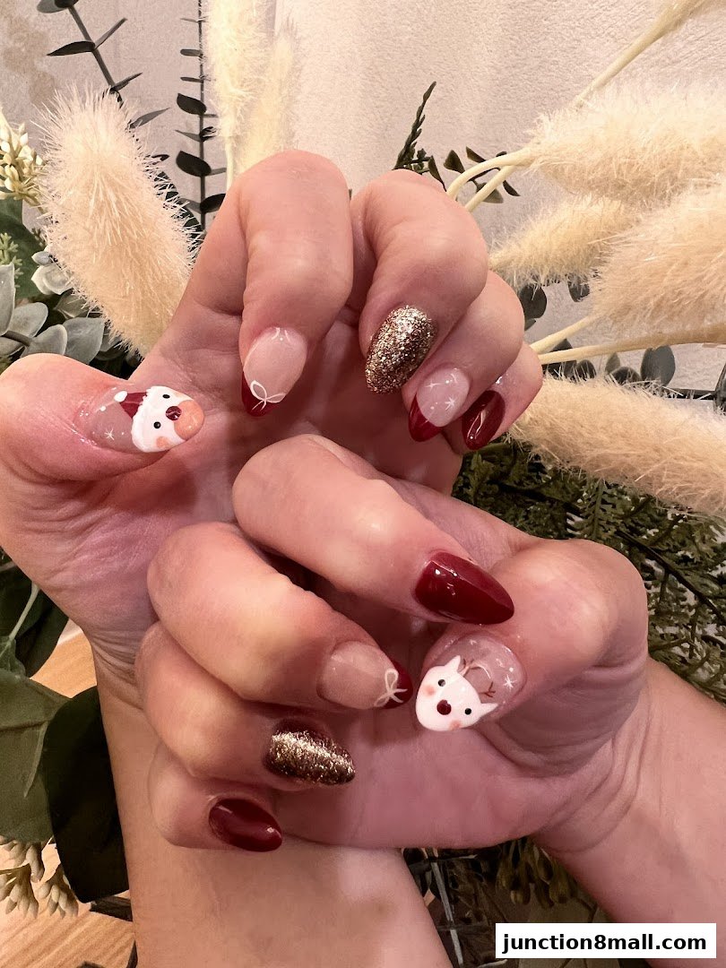 Close-up of hands with festive Christmas-themed nail art, featuring Santa and reindeer designs.
