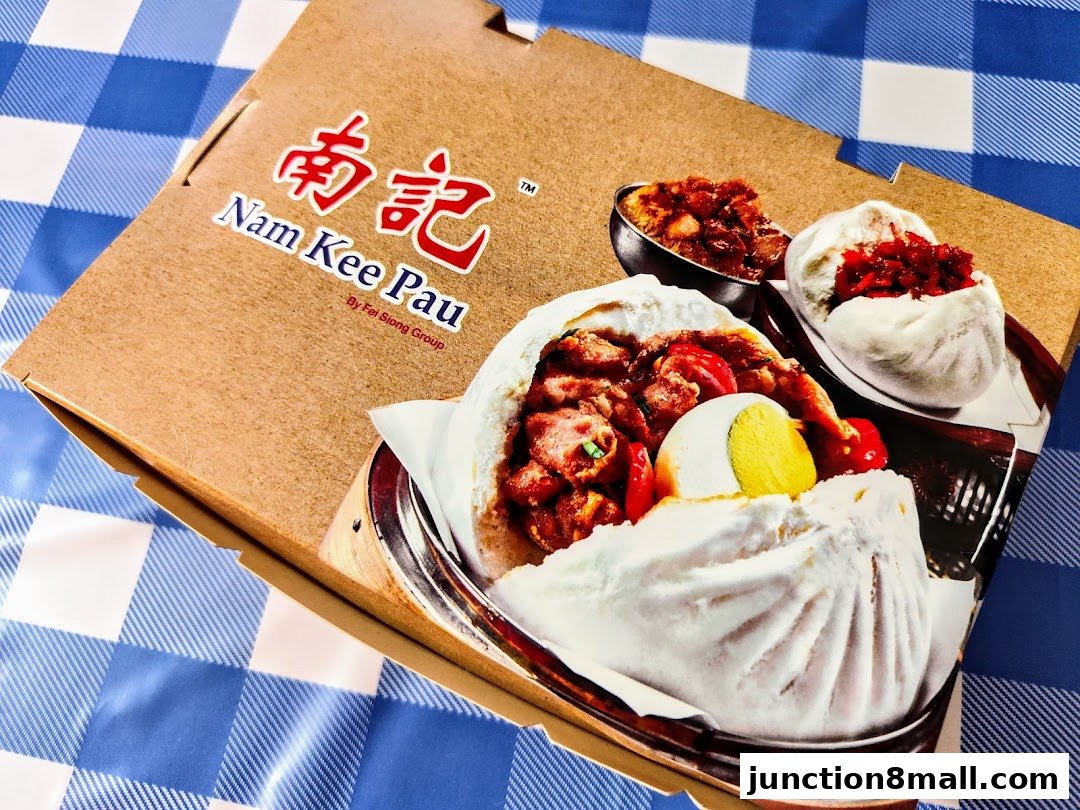 A close-up of a Nam Kee Pau food packaging showcasing delicious steamed buns with savory fillings.