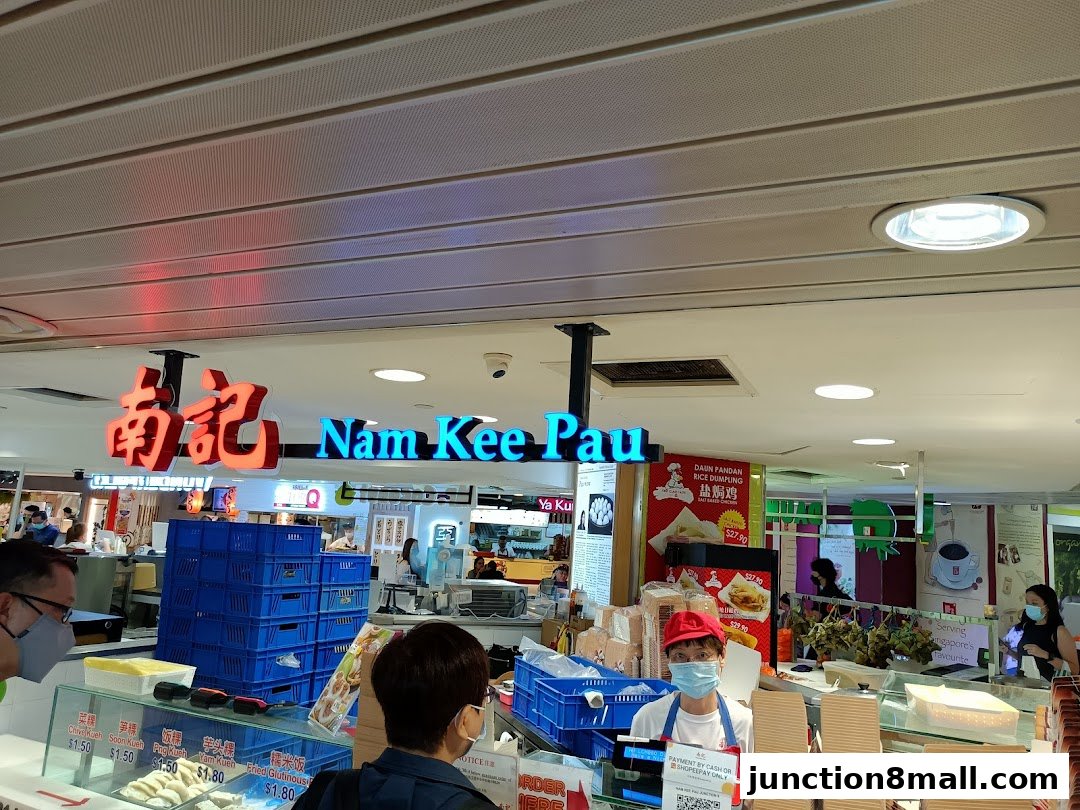 Nam Kee Pau shop front with staff serving customers and displaying various food items.