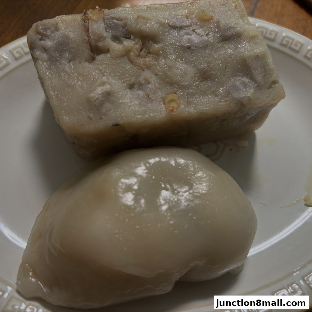 A close-up shot of two steamed buns on a white plate.
