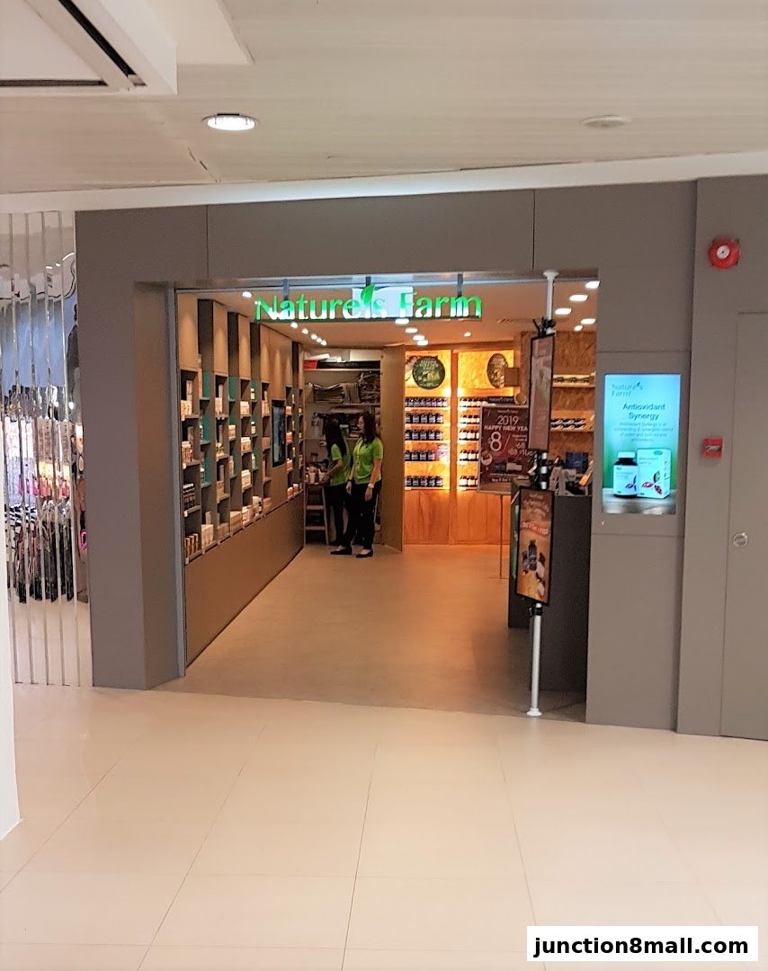 The entrance to Nature's Farm, a health and wellness store, with products displayed on shelves and staff inside.