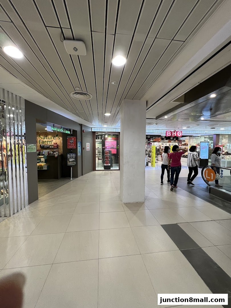 The entrance to Nature's Farm shop in a mall, with people walking by.