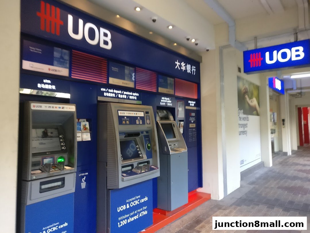 Multiple UOB ATMs are lined up outside a bank branch with signage.