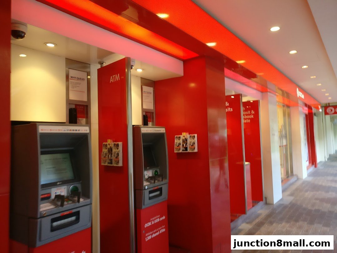 Interior view of an OCBC Bank branch with multiple ATMs and red accents.