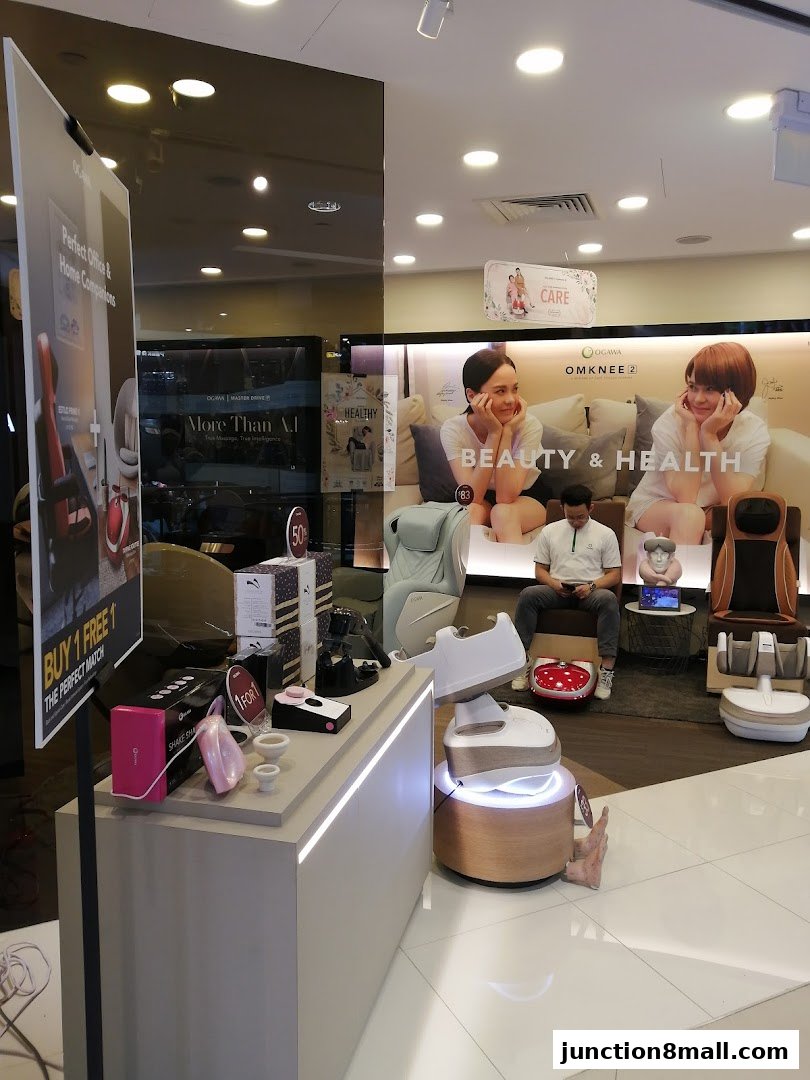 Interior of a retail store showcasing massage chairs and health products with promotional signage.