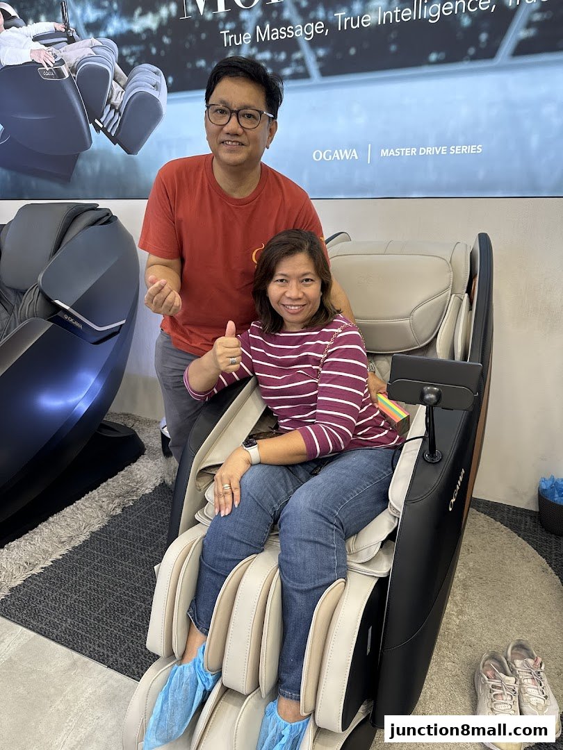 A couple smiles while testing out a massage chair at OGAWA.