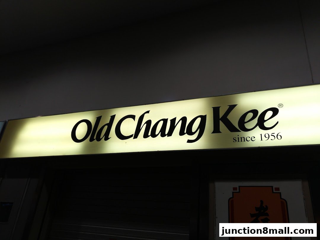 A lit sign for Old Chang Kee, established in 1956, above a closed shop.