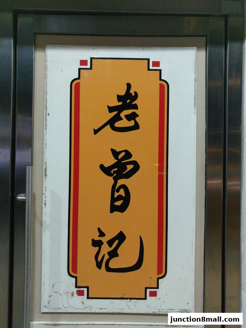 A sign with Chinese characters on an orange background, framed by red and white borders.