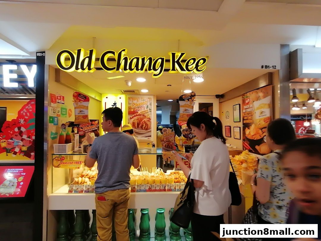 Customers at the Old Chang Kee shop, with various fried snacks displayed.
