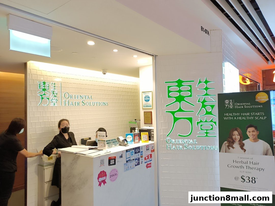 The entrance of Oriental Hair Solutions with staff at the reception and promotional posters.