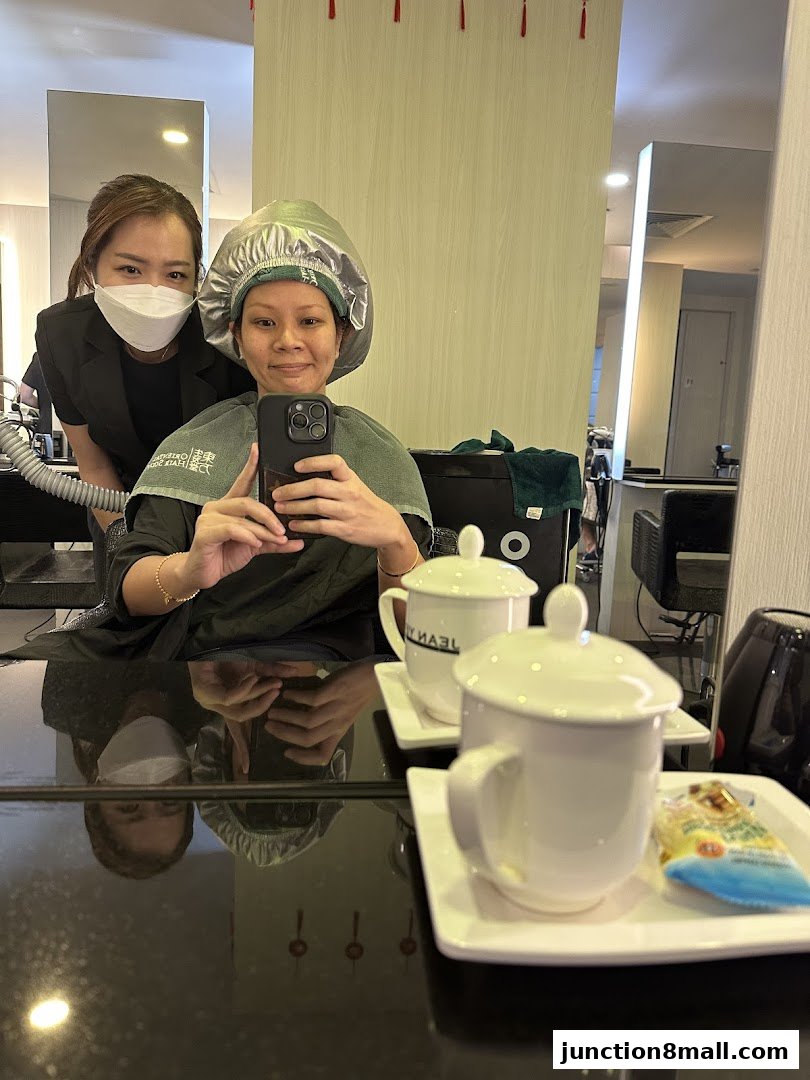 A client and stylist pose for a selfie during a hair treatment at Oriental Hair Solutions.